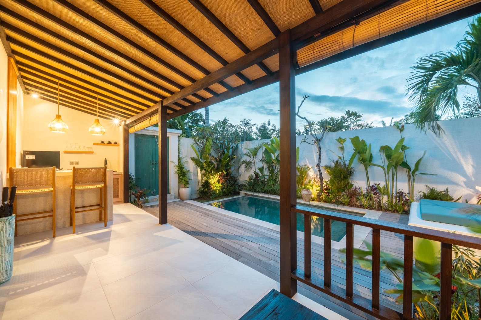 Open-air terrace with stone bar and kitchenette at dusk
