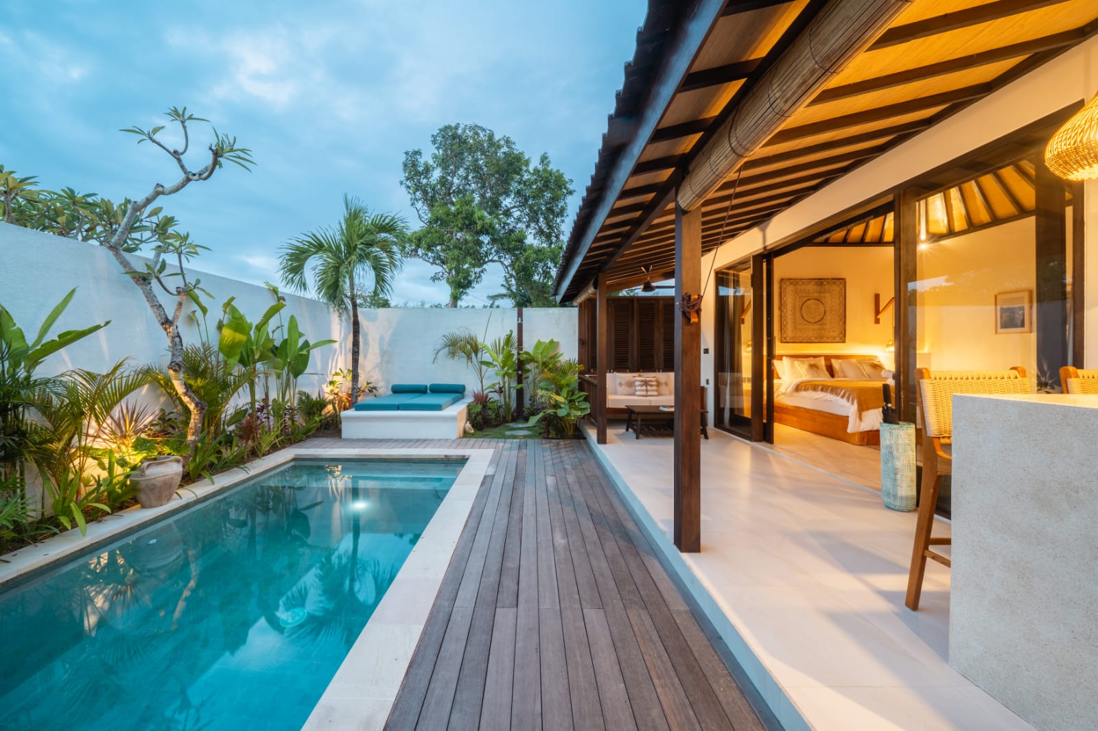 Pool, daybed and bedroom pavilion at dusk